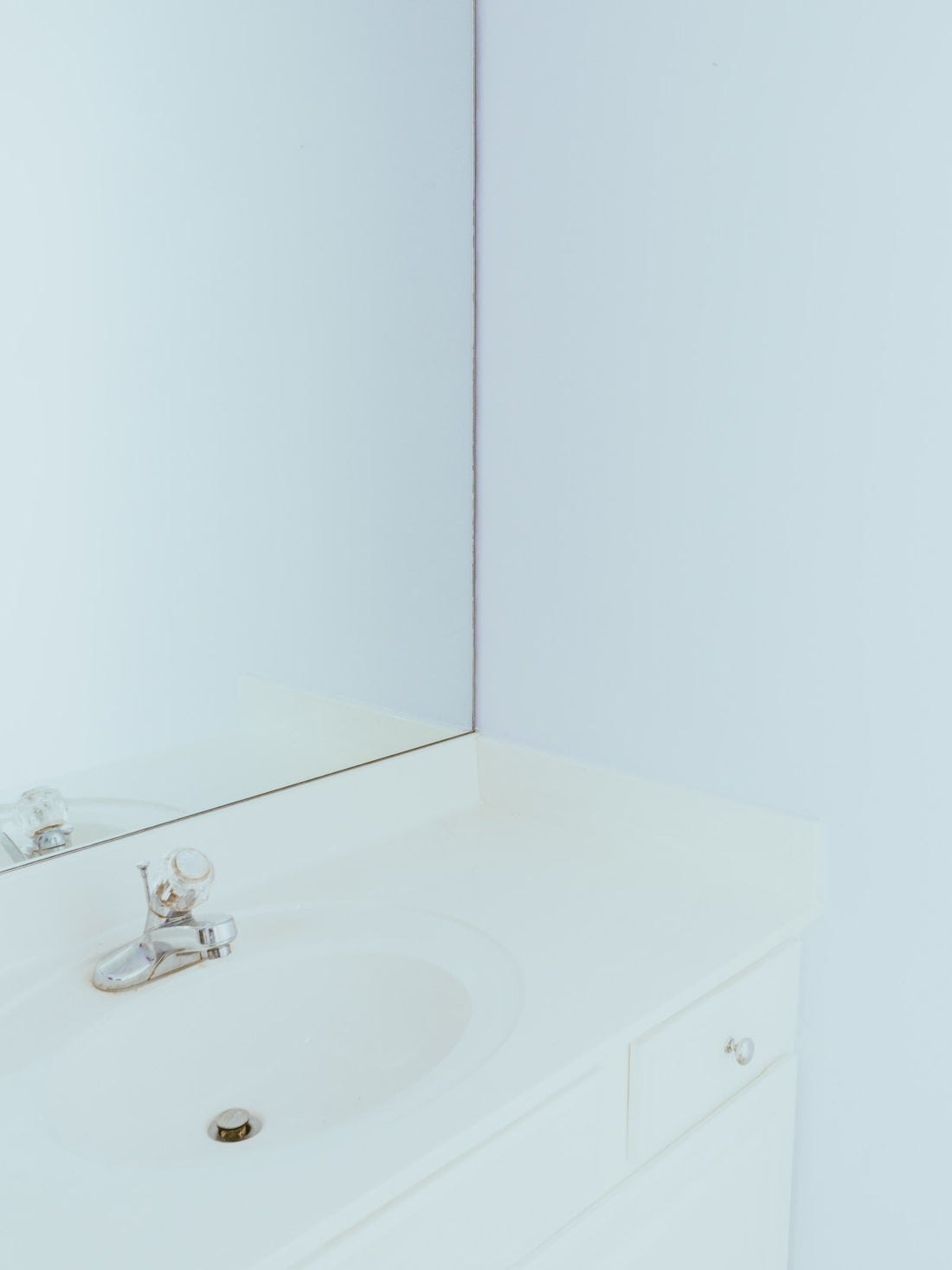 White ceramic basin and chrome faucet against a pale wall