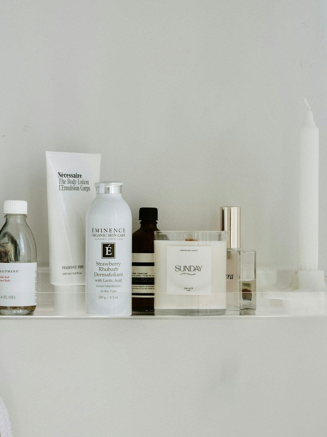 Several skincare and personal-care products arranged on a white shelf